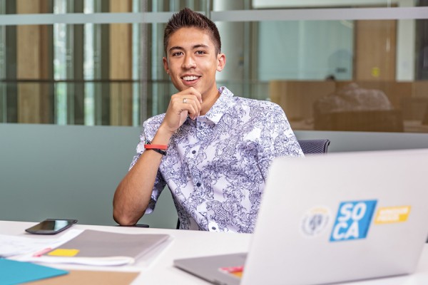 student gazing thoughtfully at laptop computer