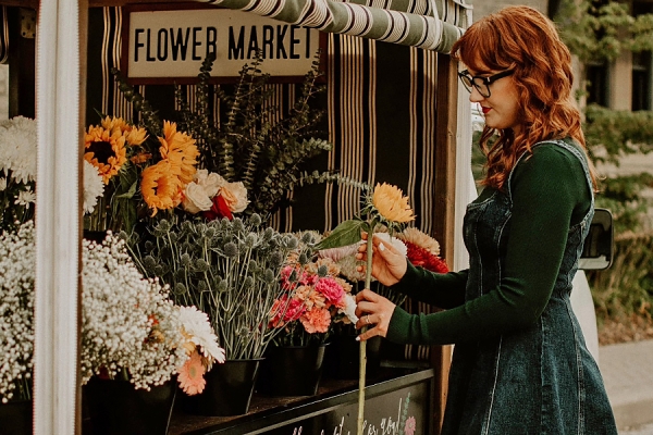 woman pulling stems of flowers from mobile bouquet shop