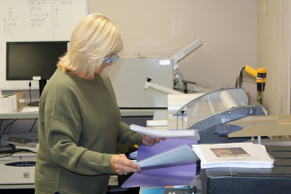 woman filling printer with paper