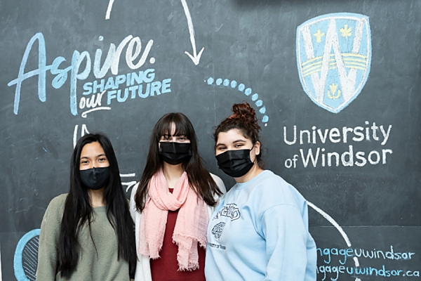 students standing in front of blackboard chalked "Aspire"