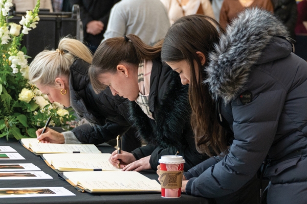 women signing book of condolence