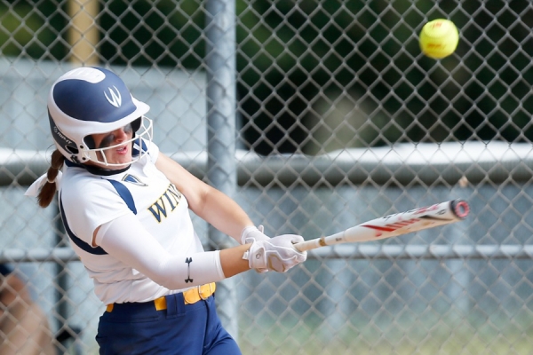 softball player hitting ball