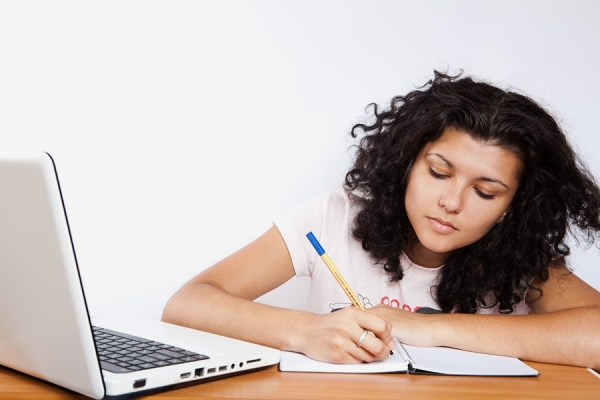 young person writing in workbook