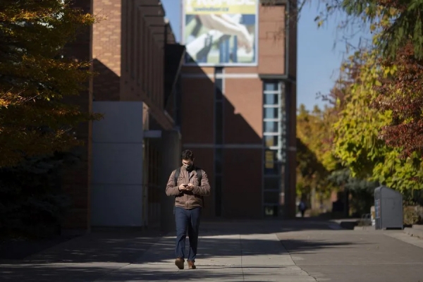 student walking behind Dillon Hall