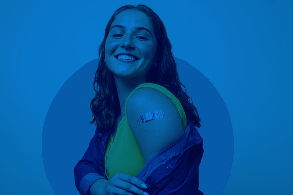 woman showing bandage over vaccination spot on upper arm