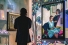 student looking at paintings on gallery wall