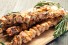 Skewers of grilled chicken souvlaki garnished with rosemary sprigs
