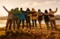 group of people facing sunrise