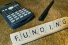 scrabble tiles spelling "funding"