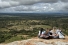 young women sitting on mountain overlooking farmed valley
