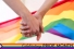 hands clasped in front of pride flag