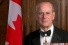 Prince Philip posing before Canadian flag