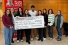 students holding novelty cheque for donation