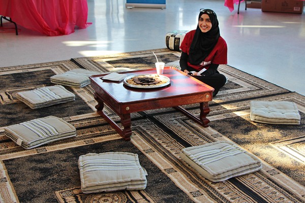 Biology major Yosra Elsayed volunteers to speak with guests on a prayer mat in the student centre Monday.