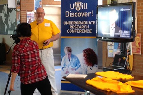 Chair Simon du Toit poses at the entrance to last year’s UWill Discover undergraduate research conference.