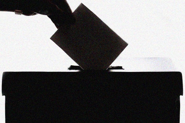 hand placing ballot in box