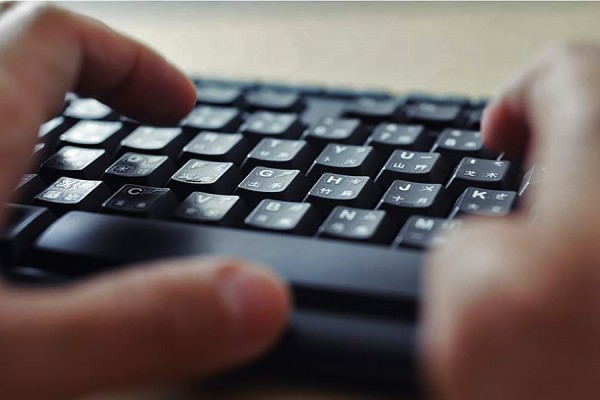 hands hovering over computer keyboard