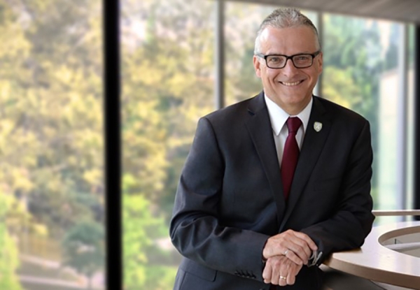 UWindsor president Robert Gordon posed casually and smiling in suit