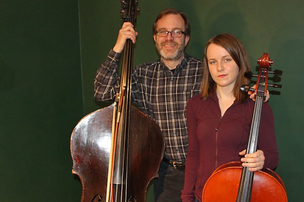 Greg Sheldon holding double bass, daughter Lyra with cello