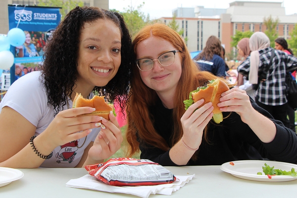 students eat hamburgers at an orientation barbecue