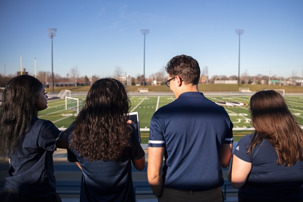 students and faculty gazing out on Alumni Field
