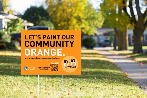 lawn sign that reads &quot;Let&#039;s paint our community orange.&quot;