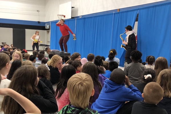 Alexa Monaco, Jaedyn Ellis, and Max Farley on stage in front of audience of kids