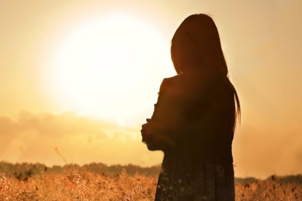 woman silhouetted against sun