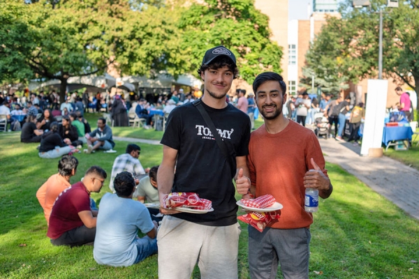 students giving thumbs-up to barbecue food
