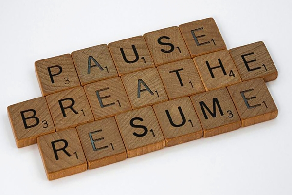 Scrabble tiles reading &quot;Pause. Breathe. Resume.&quot;