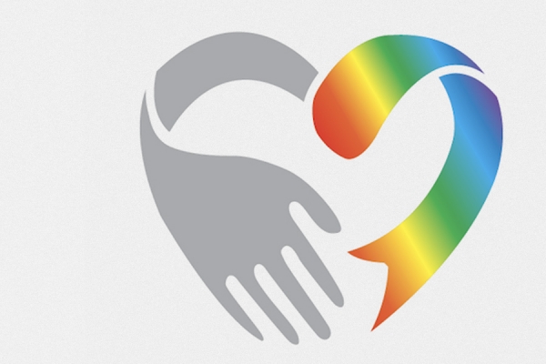 hand holding rainbow-coloured heart symbol