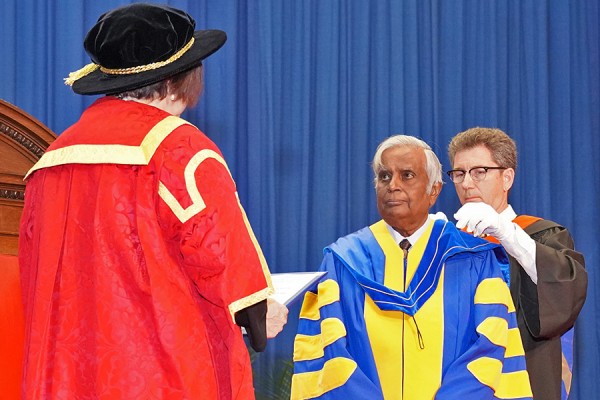 Datta Pillay receives the hood of his honorary doctorate during 2019 Spring Convocation ceremonies.
