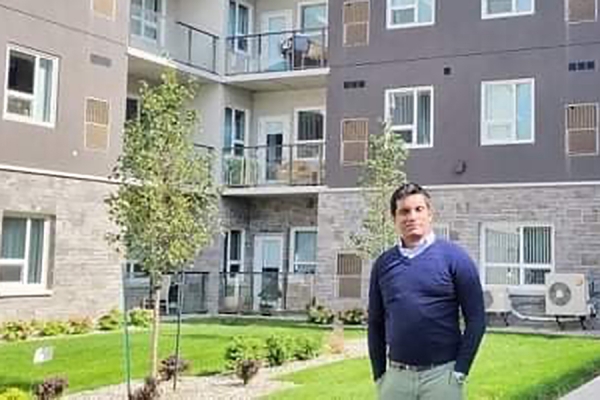 Civil engineering prof Rajeev Ruparathna standing in front of apartment building