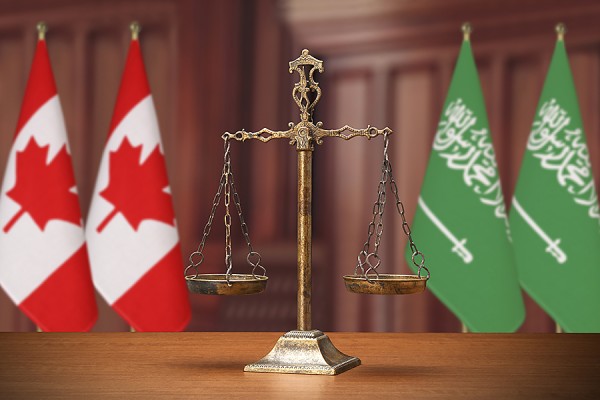 set of scales between flags of Canada and Saudi Arabia