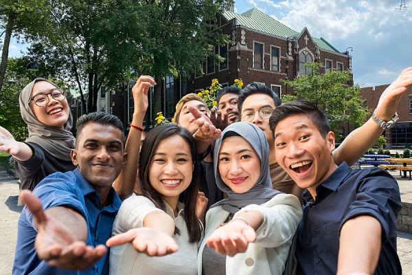 Group of smiling international students in front of Dillon Hall.
