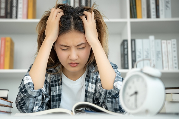 student clutching at hair during bout of study stress