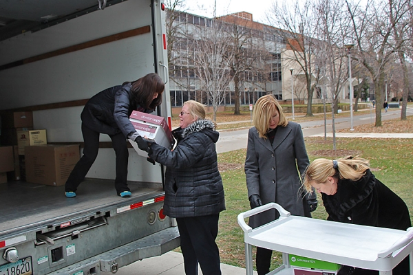 women handing boxes up to truck