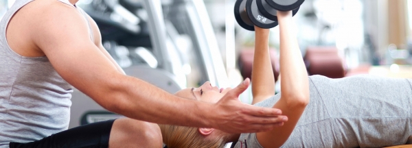 Trainer encouraging woman to lift weights