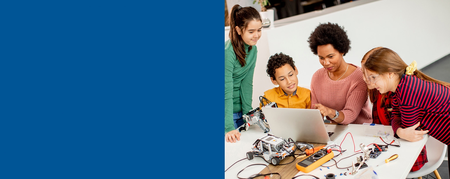Teacher and students in primary classroom setting.