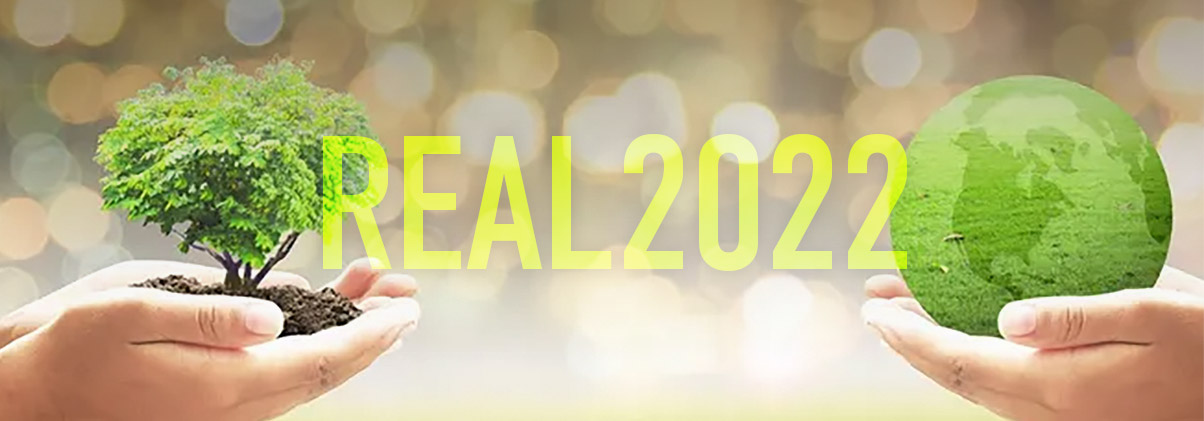Hands holding miniature tree and globe with words "REAL 2022"