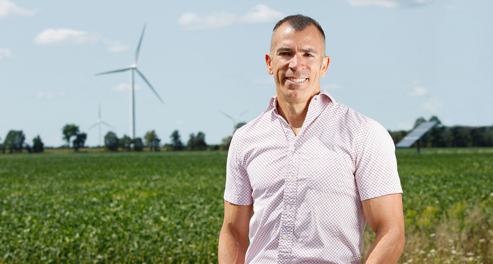 Dr Rupp Carriveau stands in front of a wind farm field