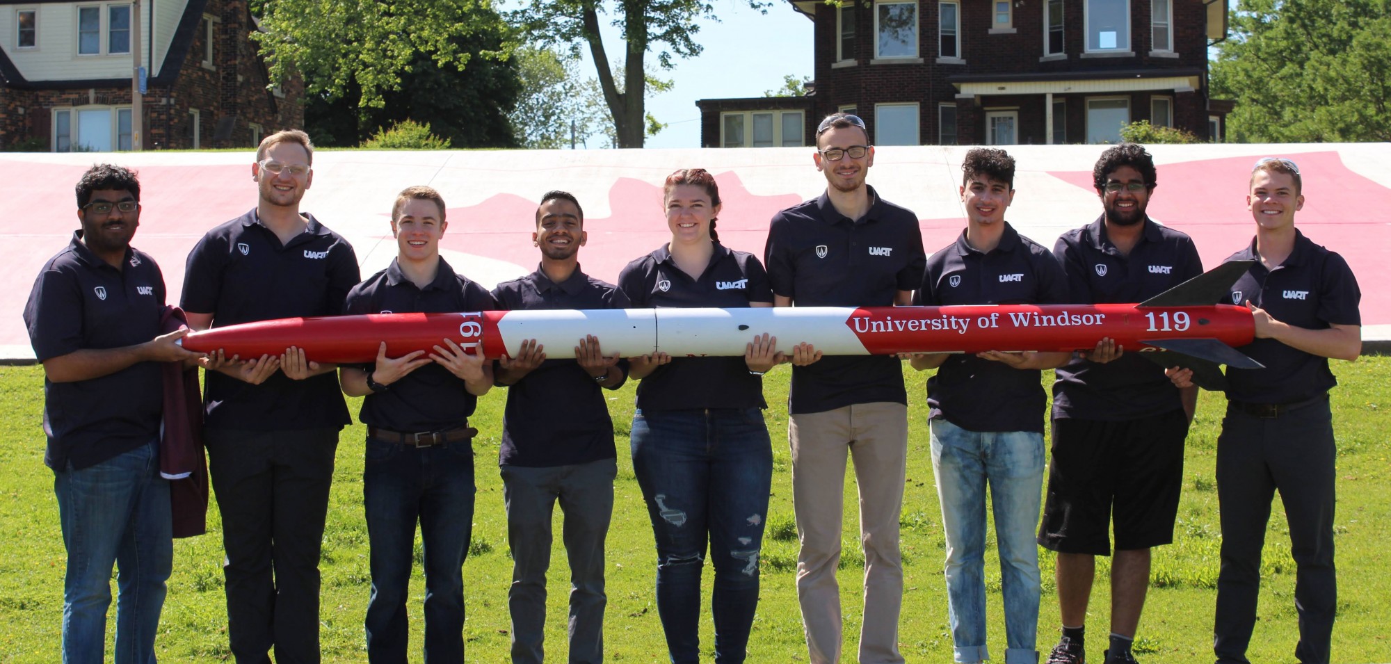 mechanical engineering students holding their rocket in the hands