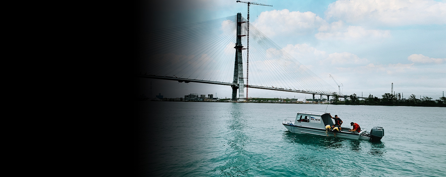 Researchers with the Great Lakes Institute for Environmental Research collect a water sample from a boat in the Detroit River
