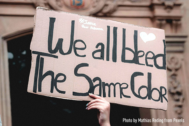 Hand holding up a cardboard sign