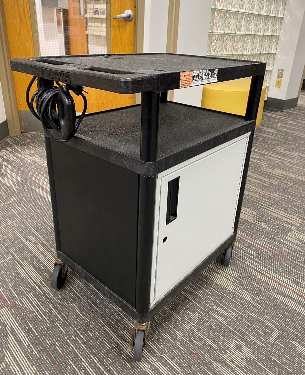 Black audio cart with white door and storage