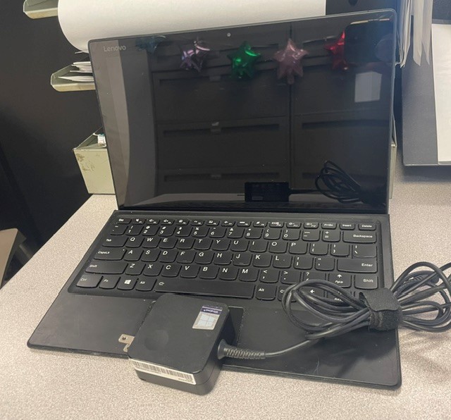 black lenovo laptop open with charger