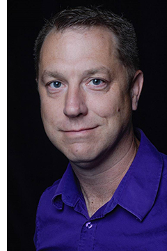 Photo of Dr. Trevor Pitcher wearing a purple shirt