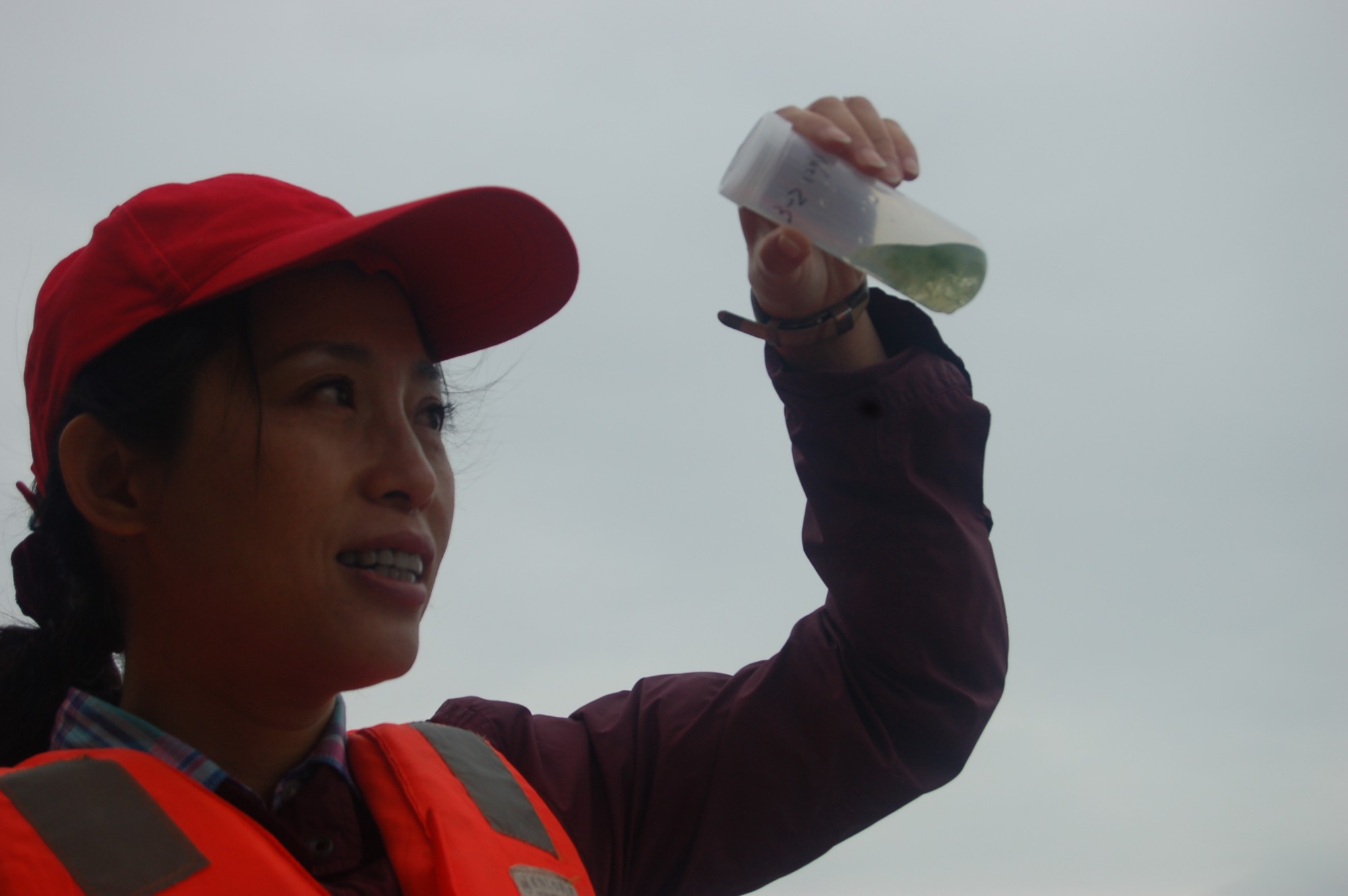 Dr. Lei Zhang examining a water sample in a vial