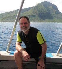 Dr. D. heath on a boat with a mountain in the background