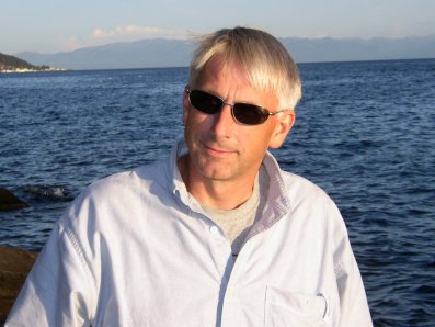 Dr. Hugh MacIsaac in a boat on a lake with mountains in the background